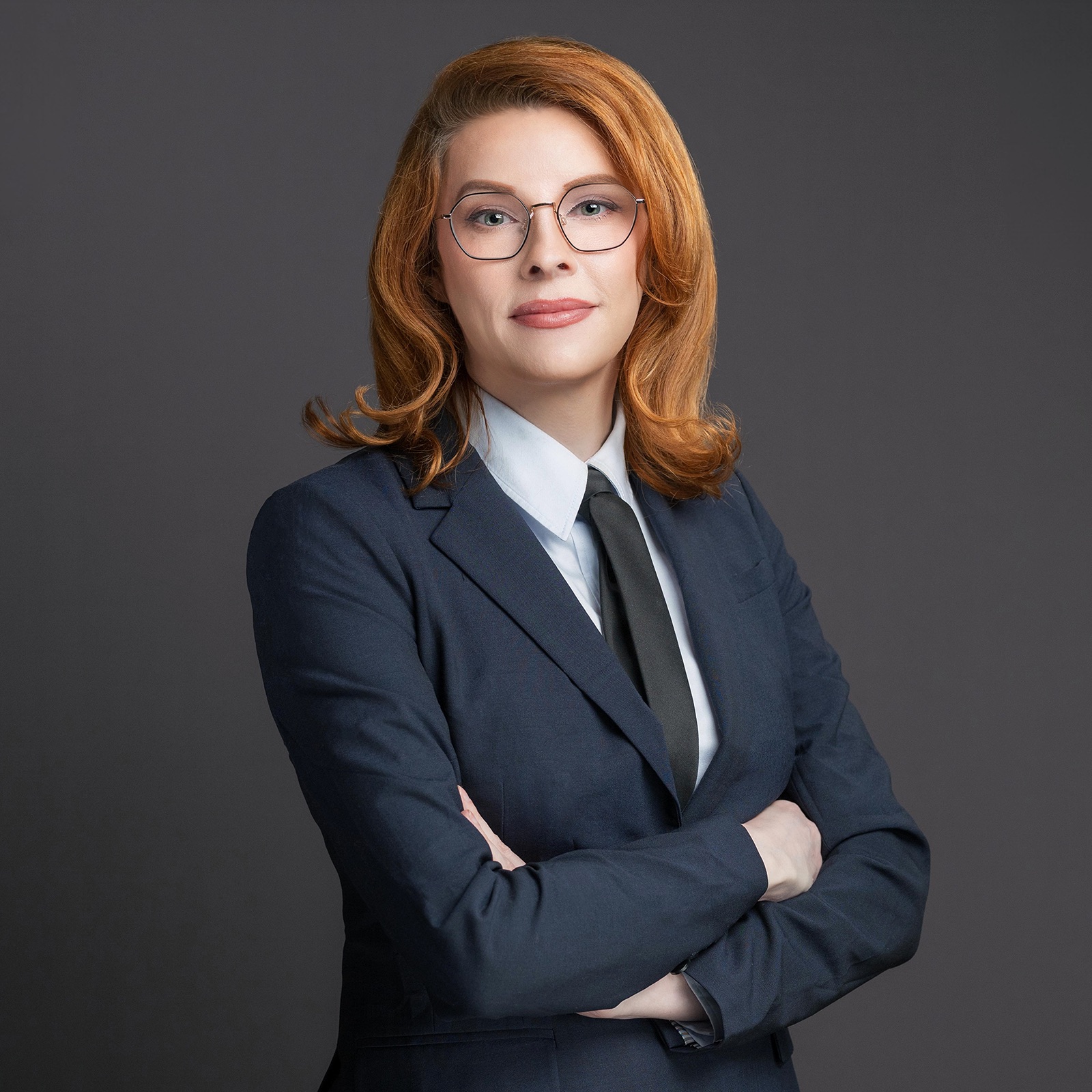Danni Askini in a navy blouse — confident professional portrait